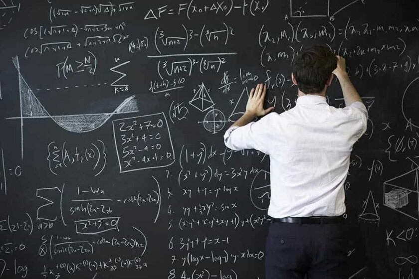 Young man writing on blackboard